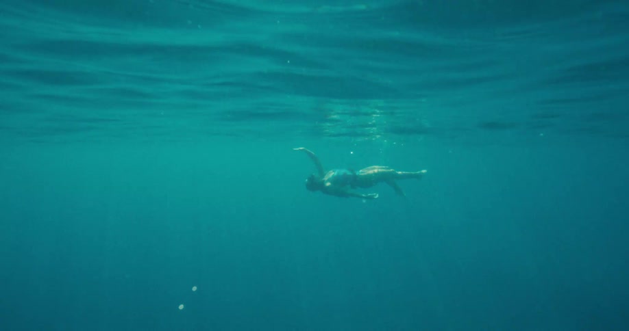 A woman swimming on her back in the ocean