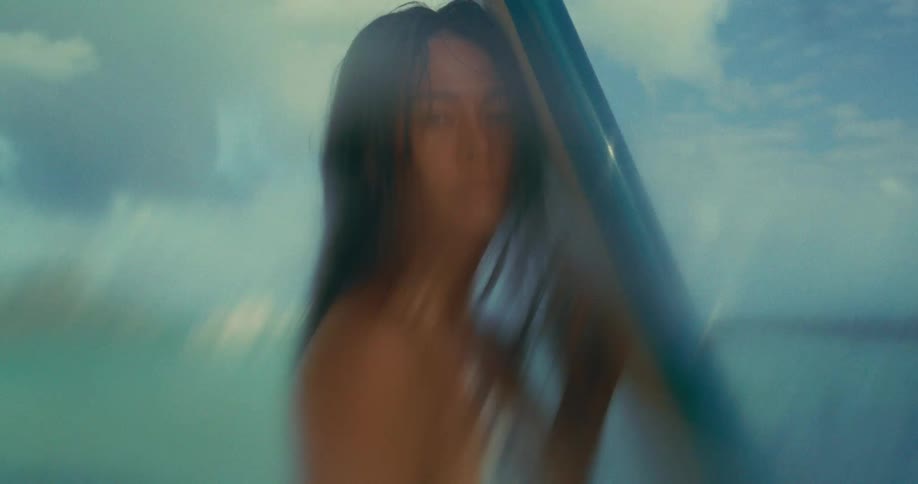 A woman holding a surfboard with a seductive and attractive look