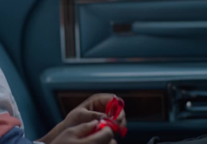 A young boy is playing with a rubber sticky toy in the back of a car