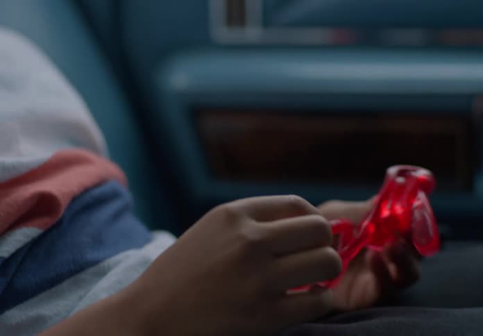 The child is playing with a toy while riding in a car
