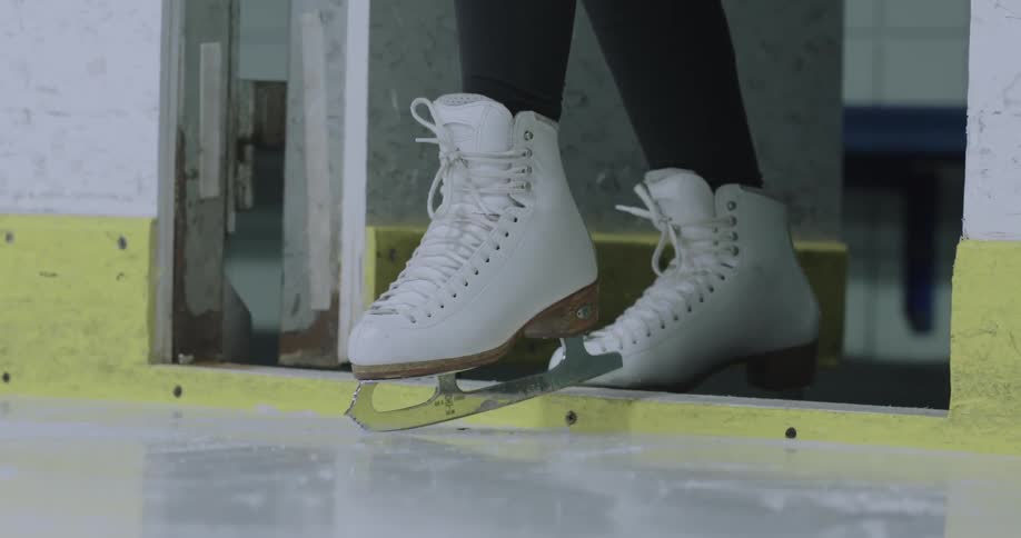 Ice skater entering onto the skating rink as seen from her shins down