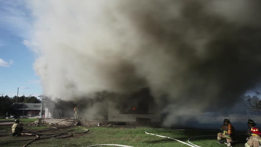 Thick smoke billows out from a house fire