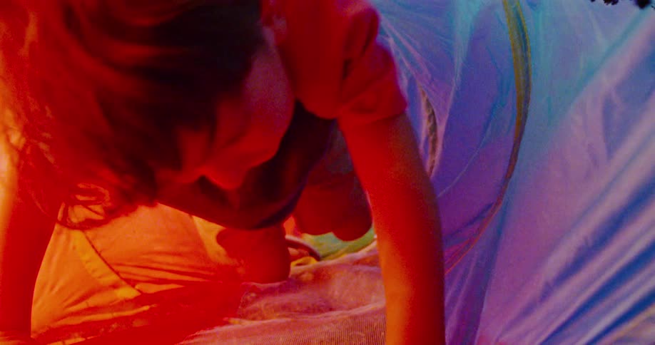 A boy playing in a colorful toy tunnel