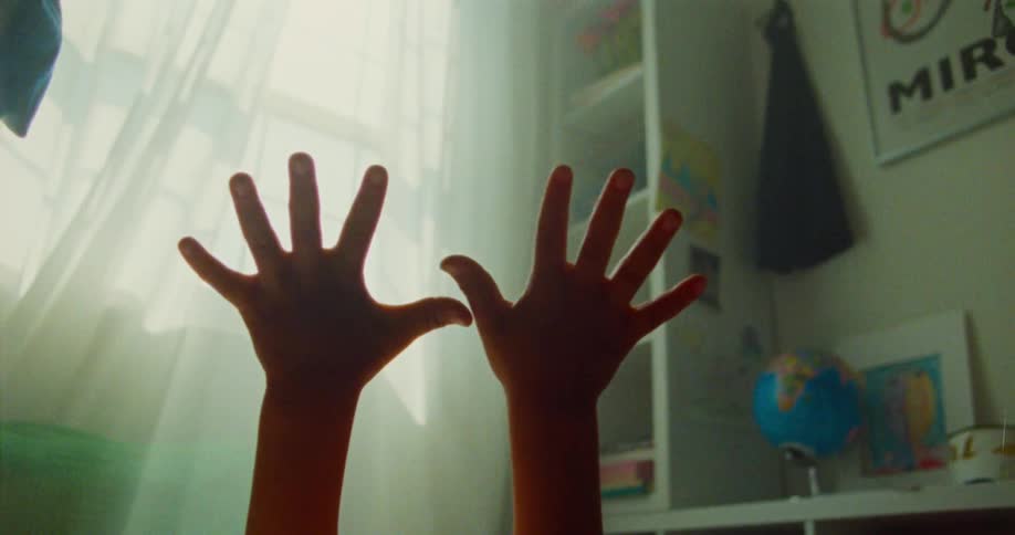 Close up of a childs hands inside a room