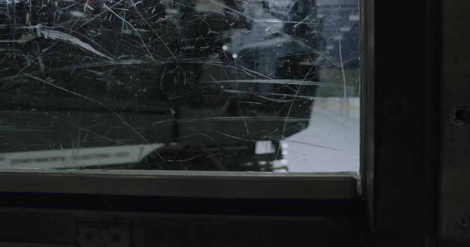 A machine is shaving the ice in a rink