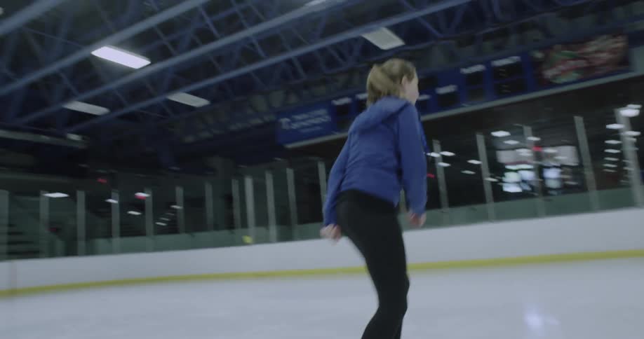 Woman ice skating on indoor ice rink