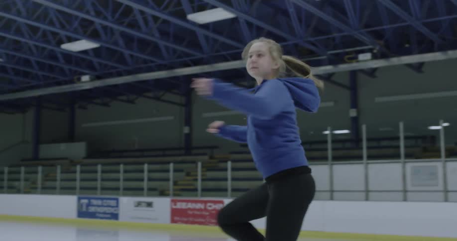 An ice skater is doing some twirls on the ice