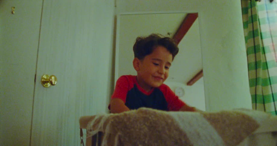 A child is digging through a laundry hamper