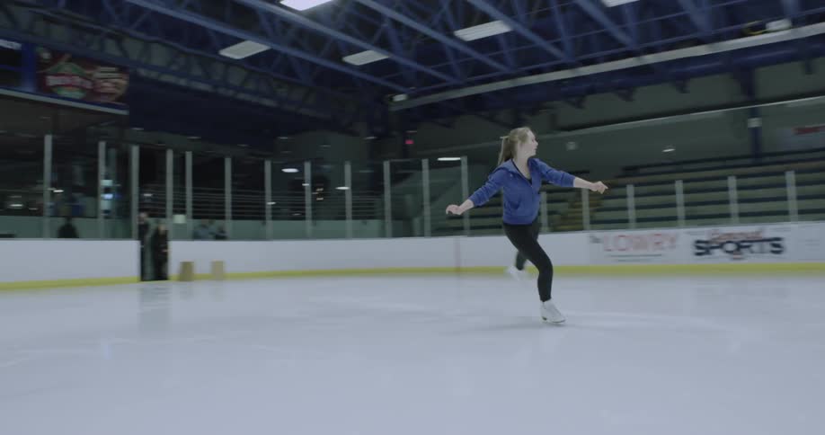 A figure skater practices jumps on the ice