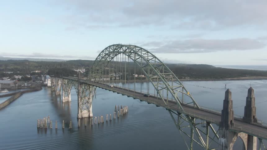 A bridge with a huge arched structure on top and cars driving over it