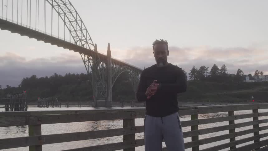 Man on a wooden bridge setting the clock and starting to run