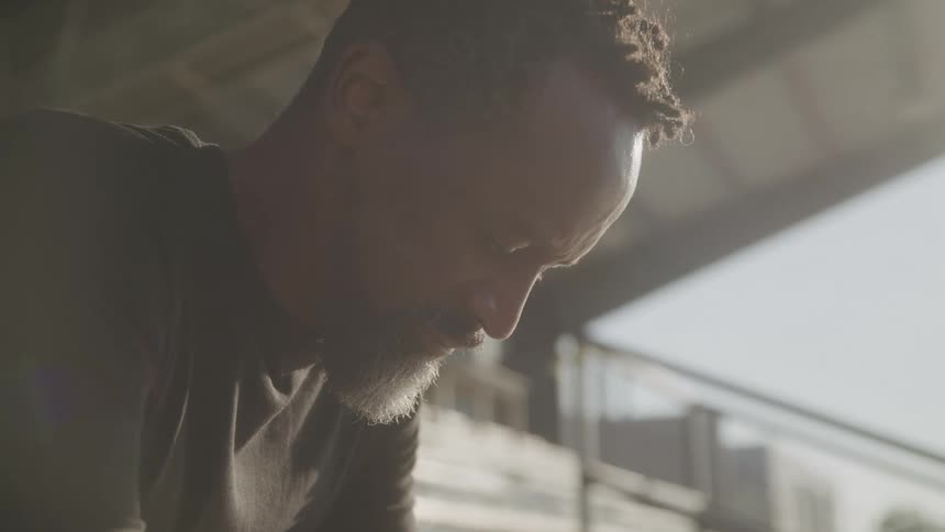 A man is sitting on the bleachers