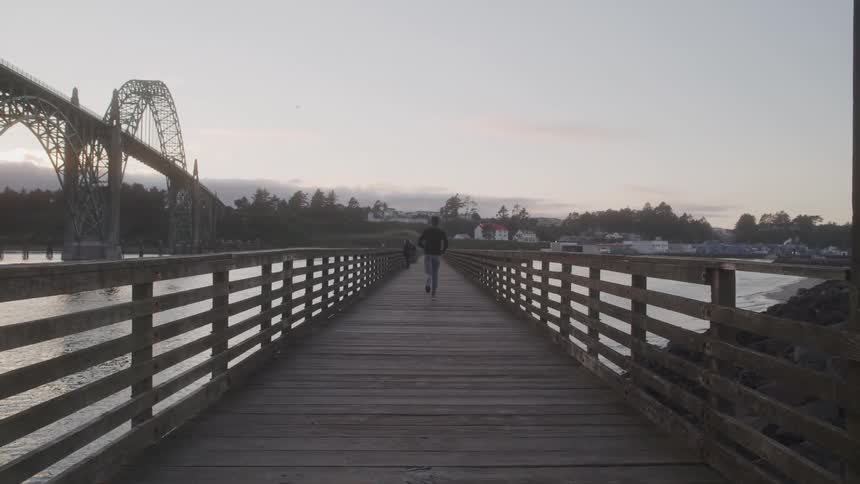 Man running across a wooden bridge in the morning