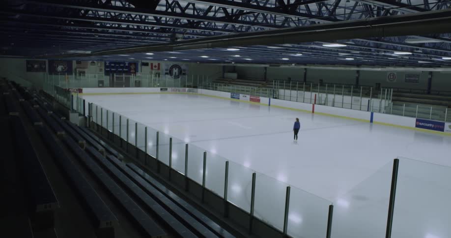 Woman skating solo on an empty skating rink