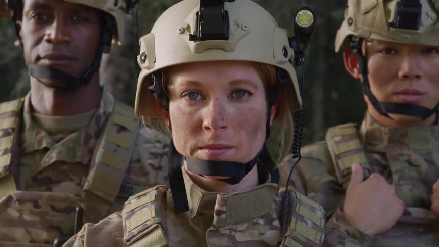 Three soldiers with their heads turned to the sides begin to turn their heads forward and stare straight ahead