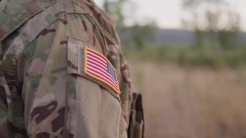 The soldiers uniform has an american flag patch ono the shoulder