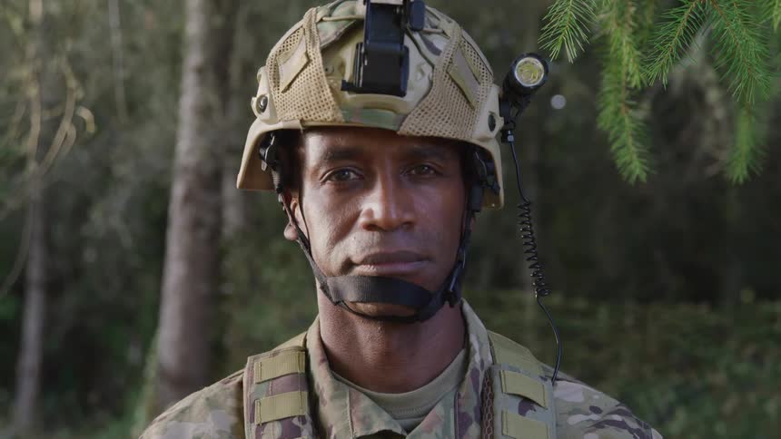 Portrait of a military man with a helmet in a tree environment