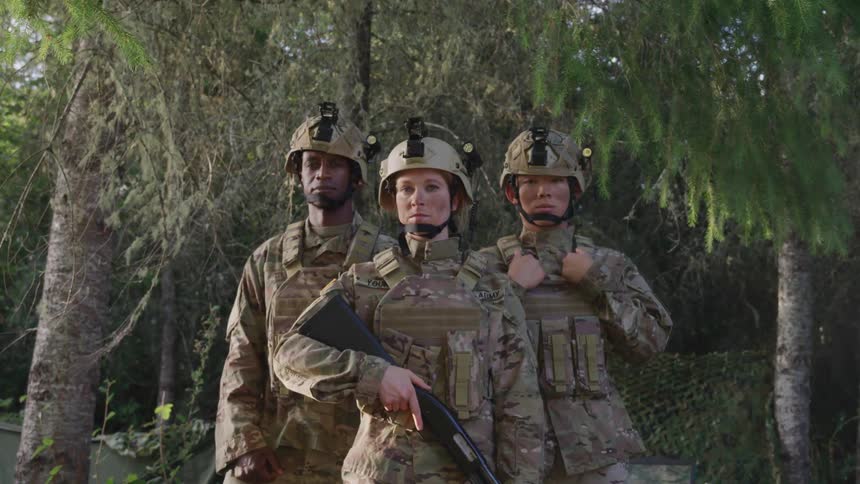 Three soldiers stand in the forest together