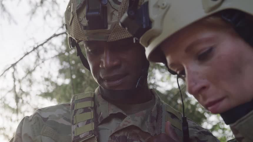 Portrait of a man and a woman both military with protective helmet outdoors in the forest