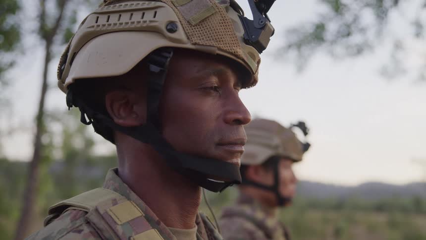 Two soldiers are standing outside on a cloudy day