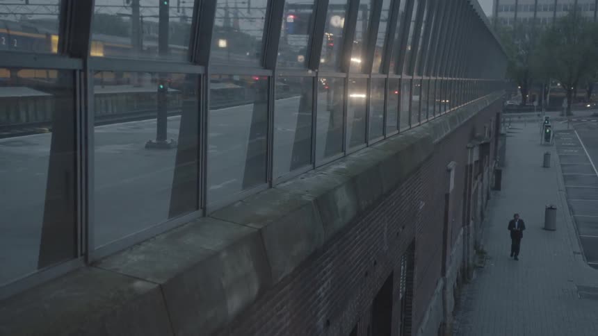 Person walking down a city sidewalk at dusk
