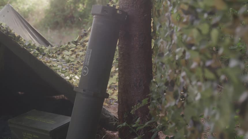Supplies are leaning against a tree by the tent