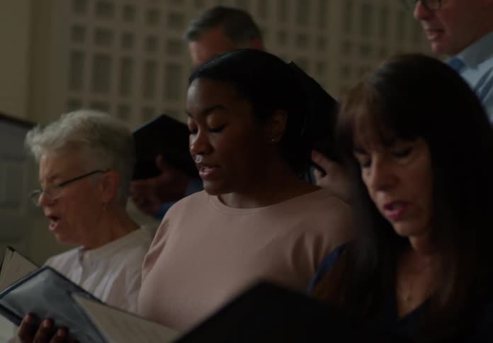 Man plays the piano to accompany a church choir