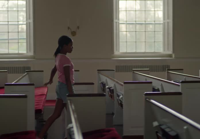 Girl walking between the pews of a church