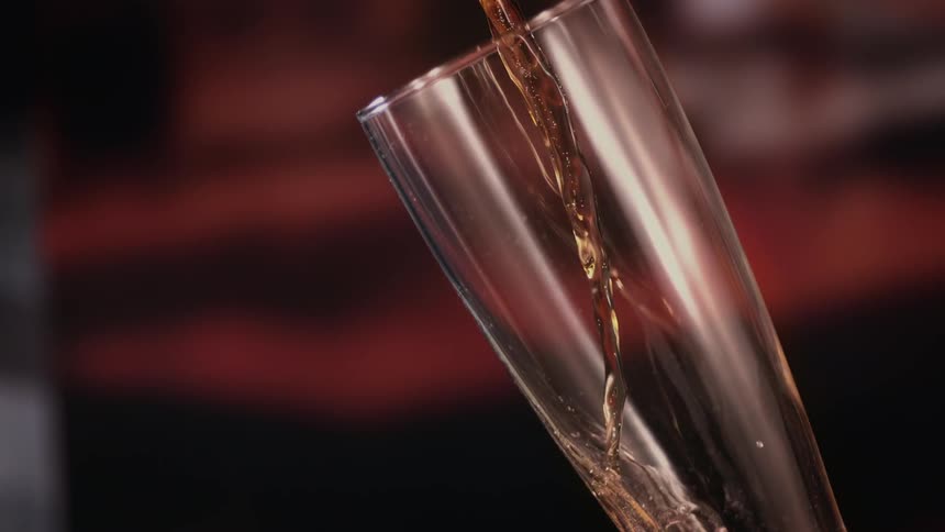 Beer is being poured from a bottle into a glass