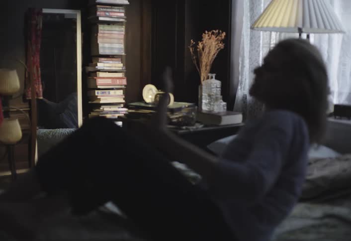 A woman waking up looking at the mirror and getting out of bed
