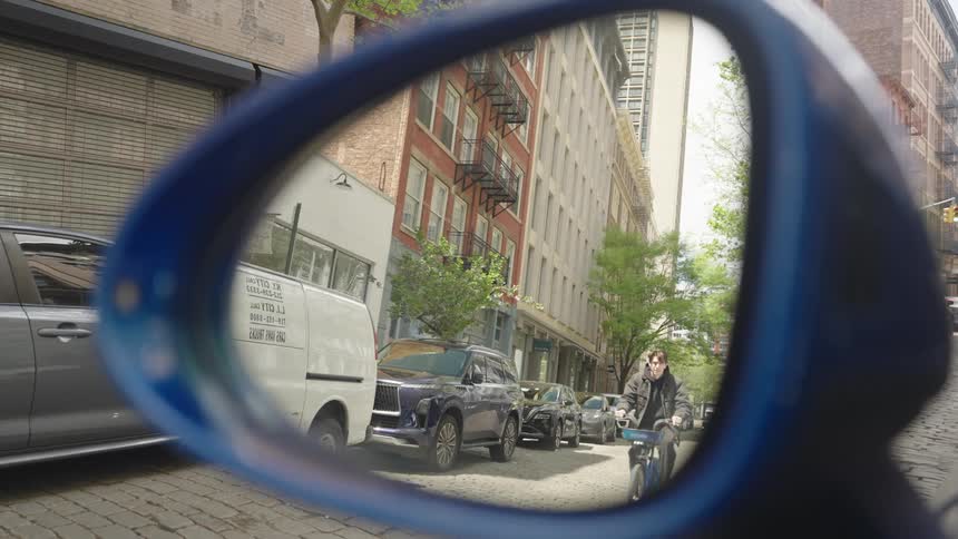 A man rides is bike down the city street