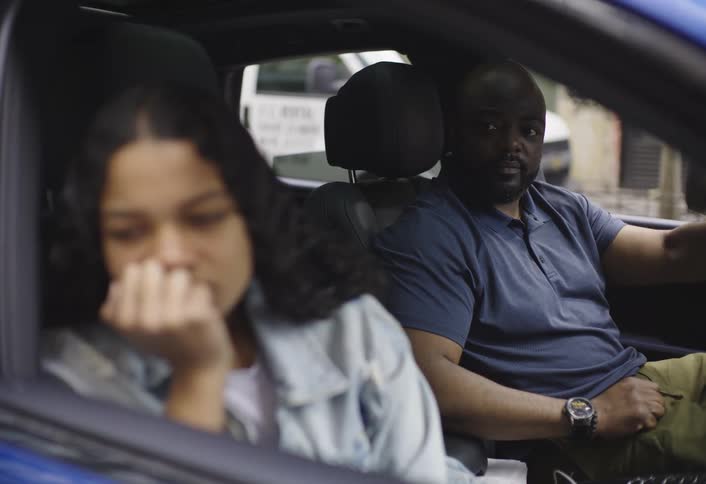 A father and his young daughter argue inside a parked vehicle in the city