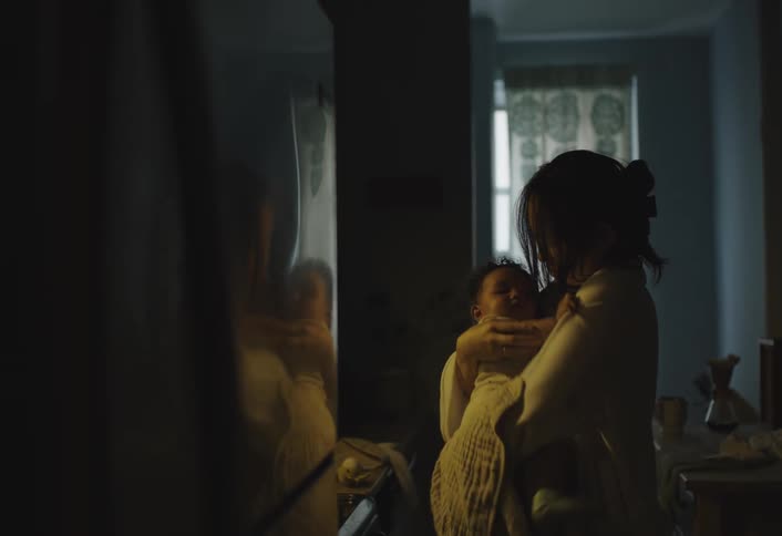 Mother checks the freezer compartment then holds her baby