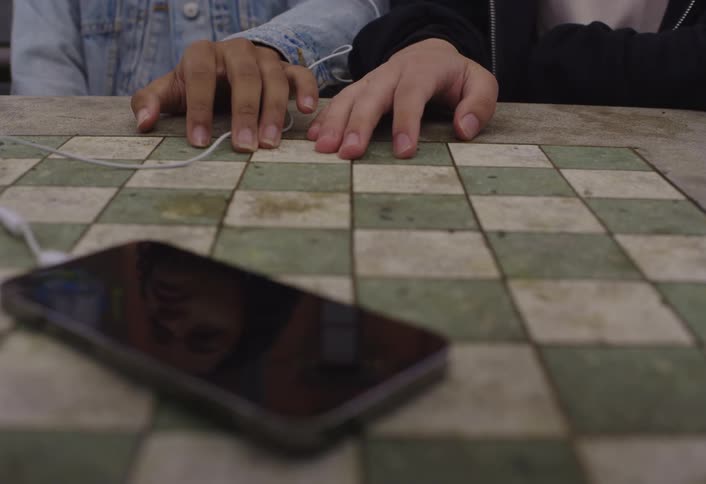 Two people slowly hold hands by the phone