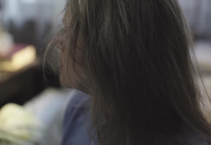 A woman sits up in bed and gets up