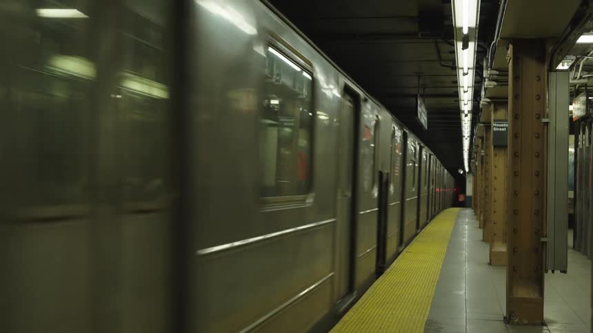 A subway train is arriving at an underground station platform