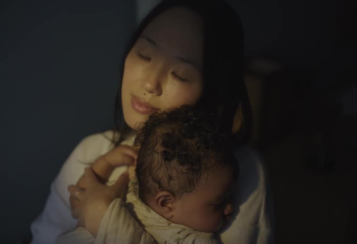 Mother hugging her sleeping baby in her arms