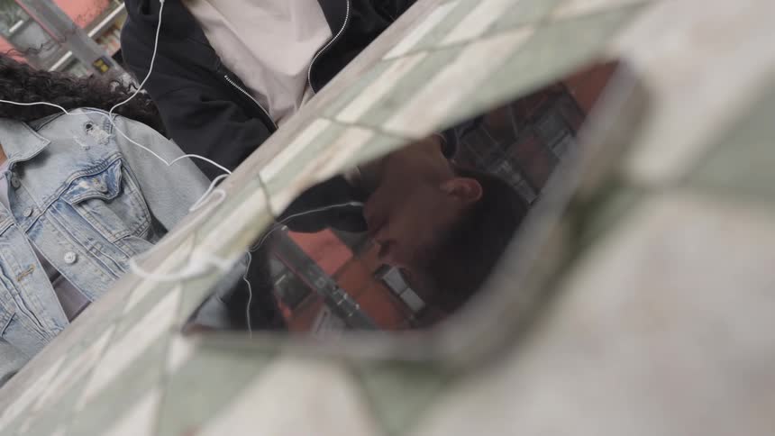Closeup of two people sharing earphones and listening to music together