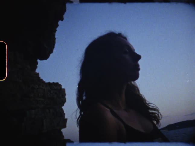 A womans eyes are closed by the rocks