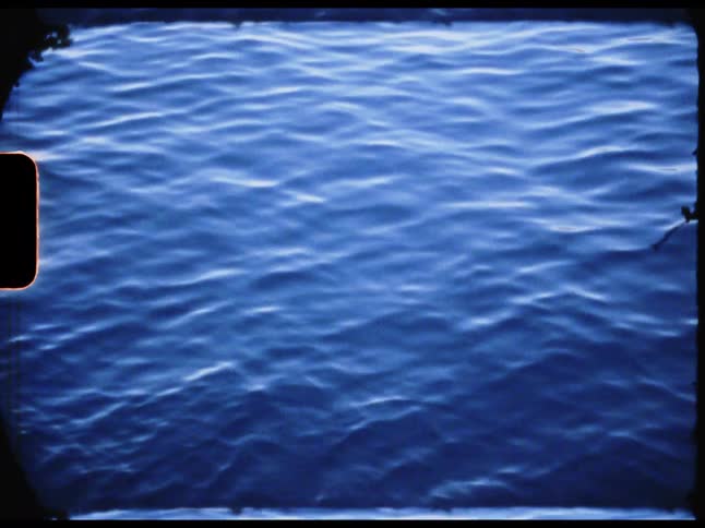 The ocean water reflects the blue sky as gentle midday winds create a ripple effect across the surface
