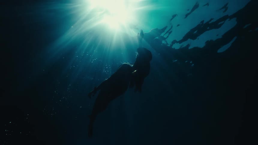 A woman is floating underwater