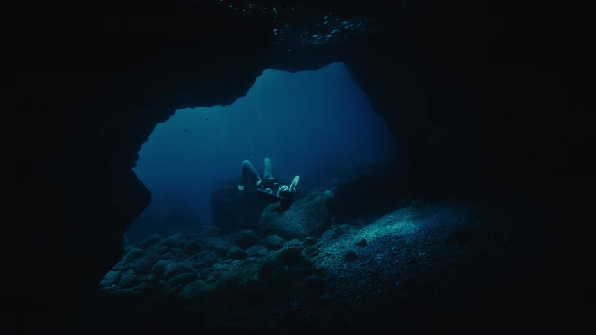 A woman dives into the underwater cave