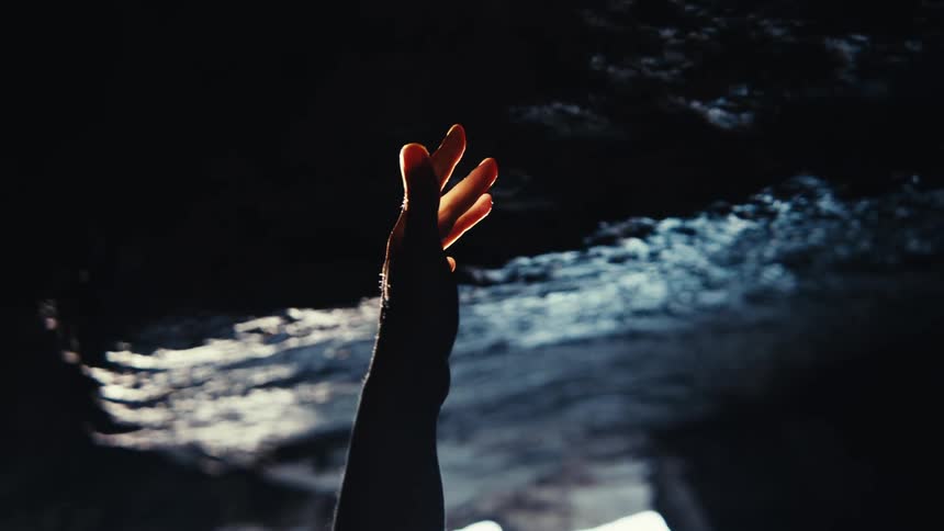 Close up of a female hand in a natural cave environment