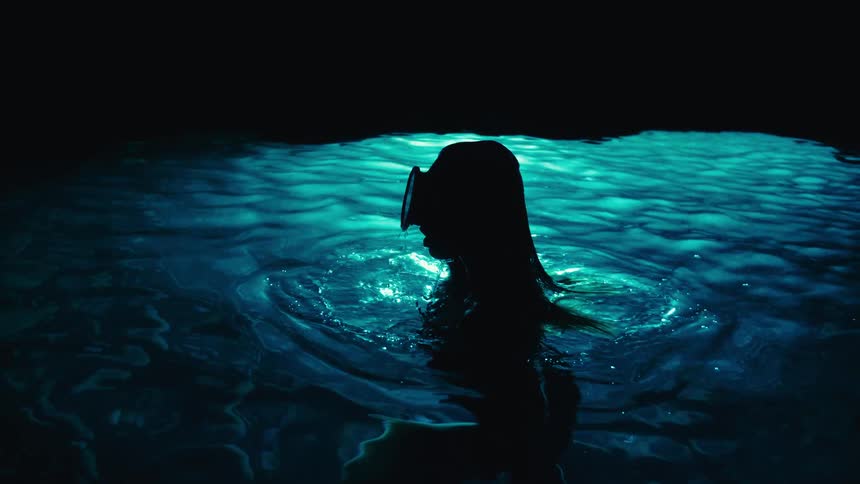 Silhouette of a woman snorkeling swimming in the waters of a cave