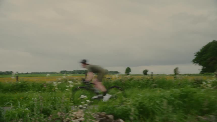 Cyclist speeding through a countryside environment on a cloudy day