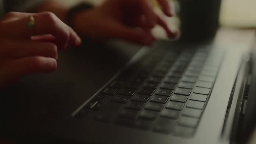 The woman is typing on her laptop