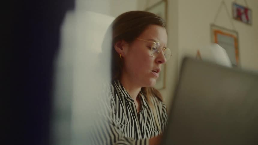 The woman is talking and writing on papers