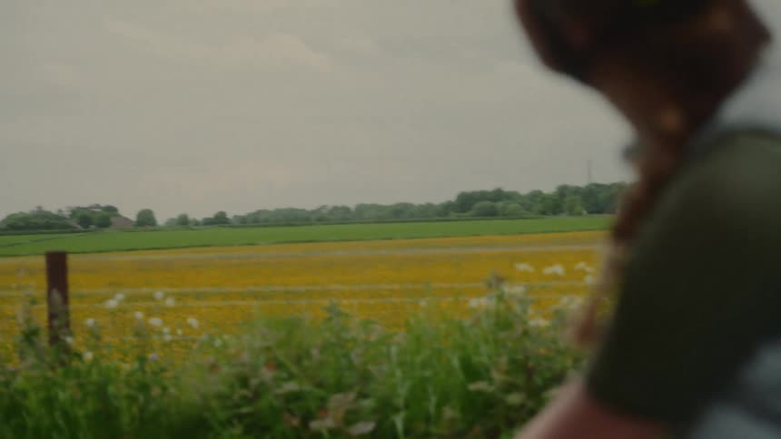 Female cyclist wearing a helmet is in a natural countryside environment