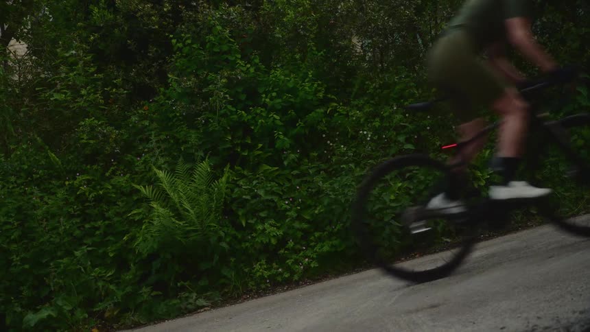 Female cyclist climbing a steep road