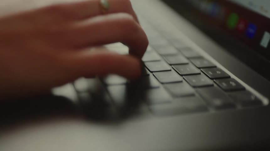 Pair of hands typing quickly on a laptop